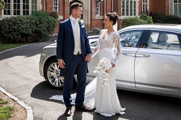 Bride and Room stood next to car outside Warwick School